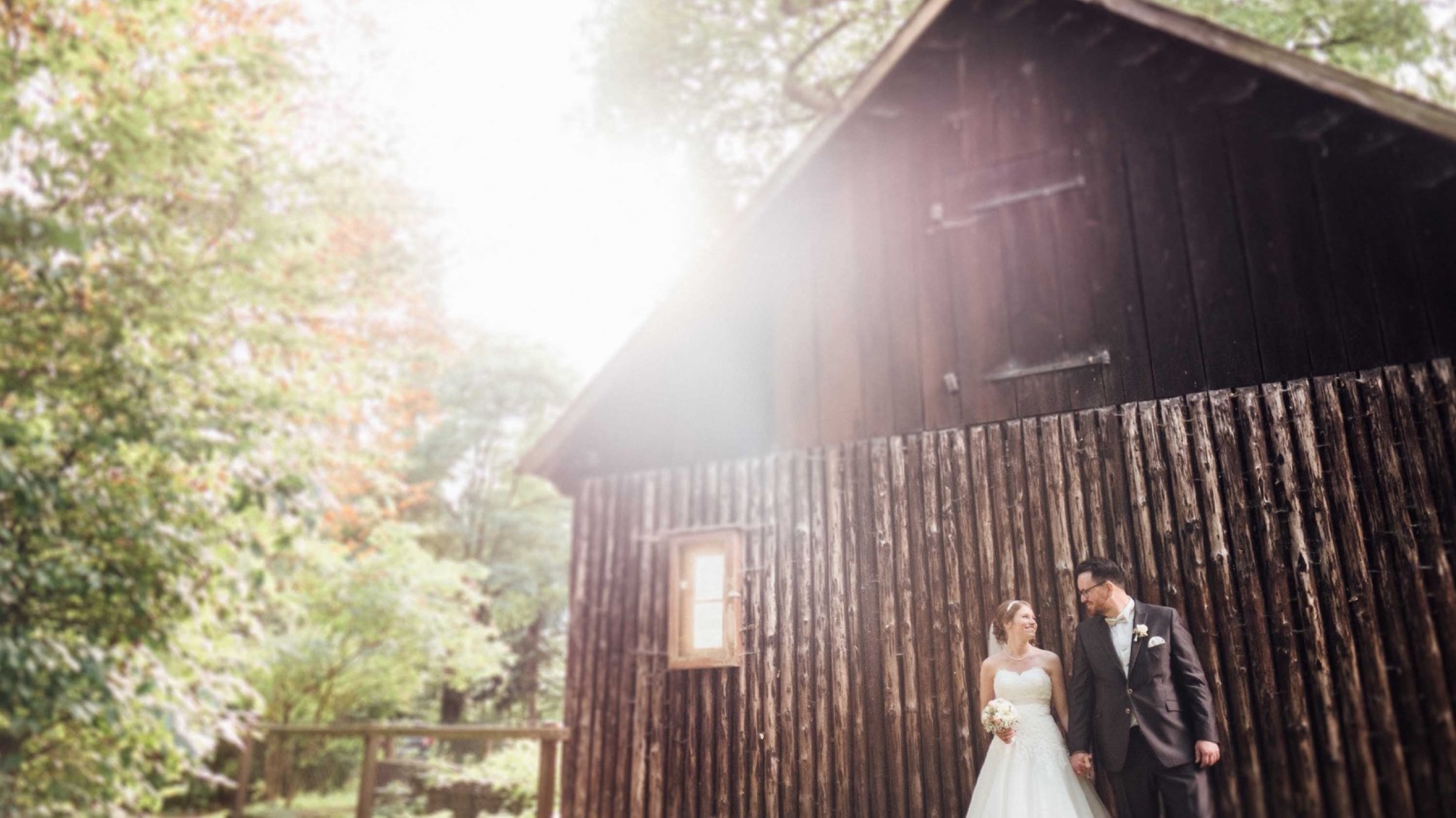 Hochzeit in Bremen: Brautpaar Hand in Hand vor einer alten Scheune