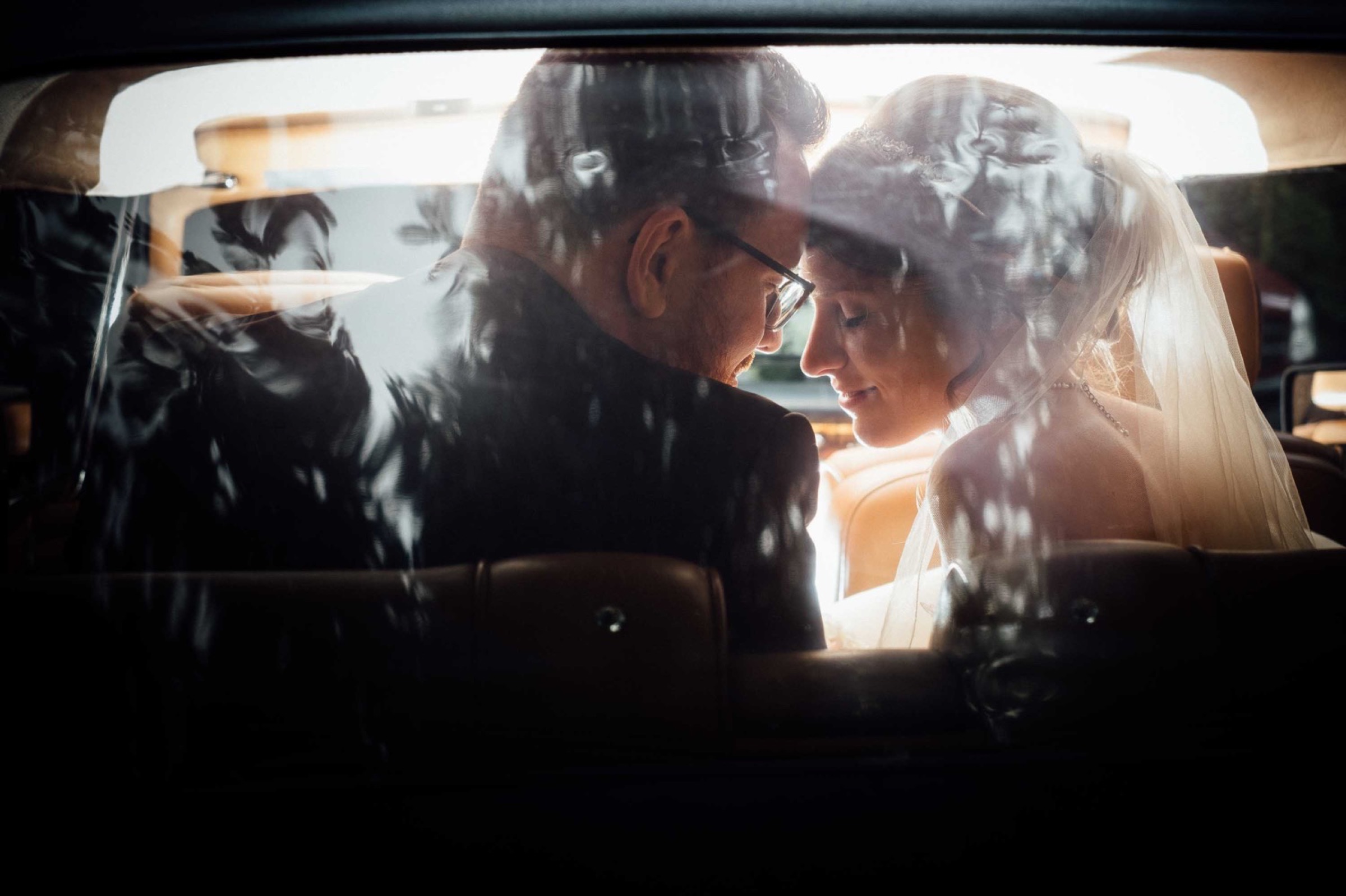 Hochzeit in Bremen: Brautpaar im Auto lehnt die Stirn aneinander