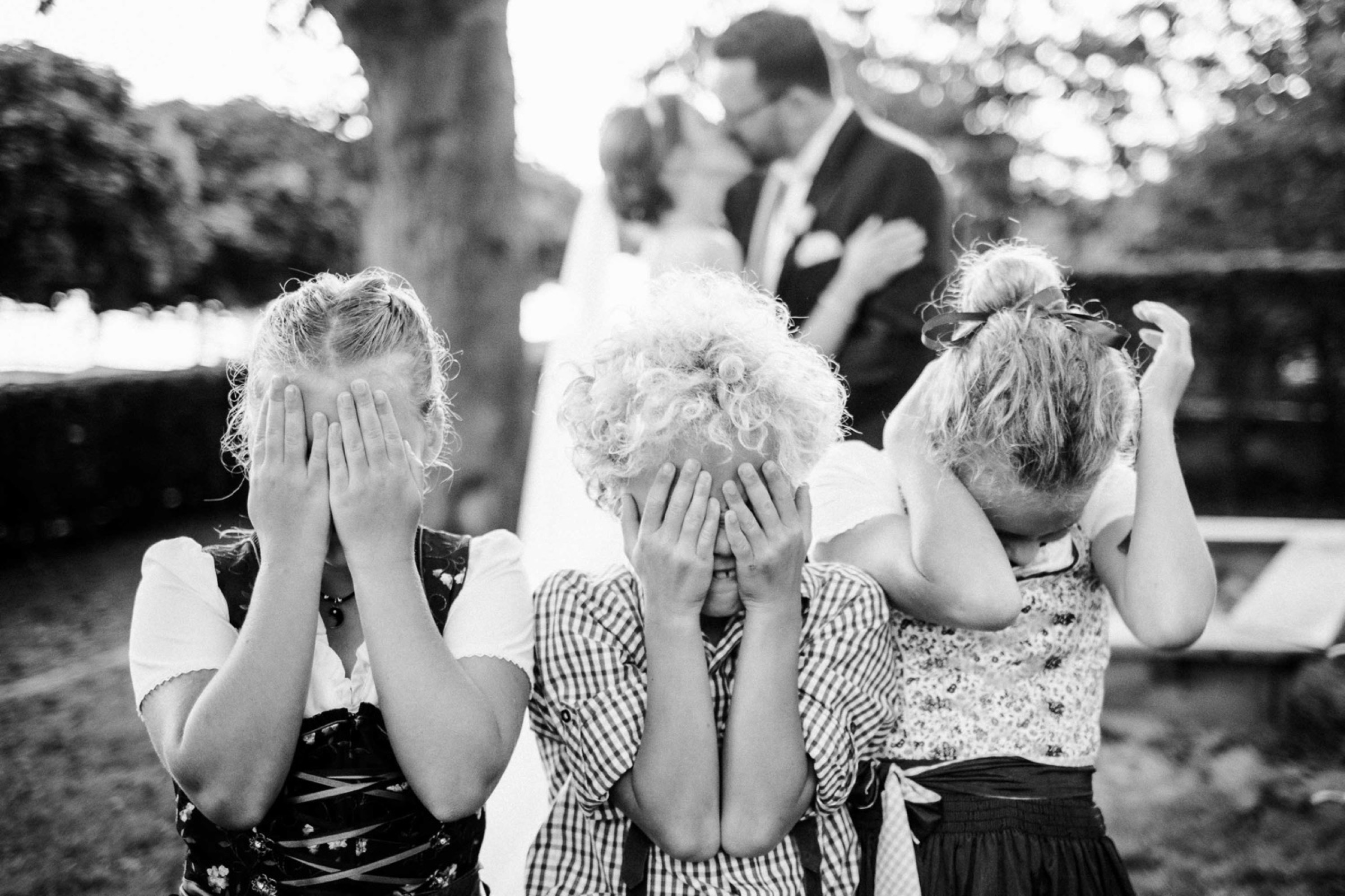 Hochzeit in Bremen: drei Kinder halten sich die Augen zu, im Hintergrund küsst sich das Brautpaar