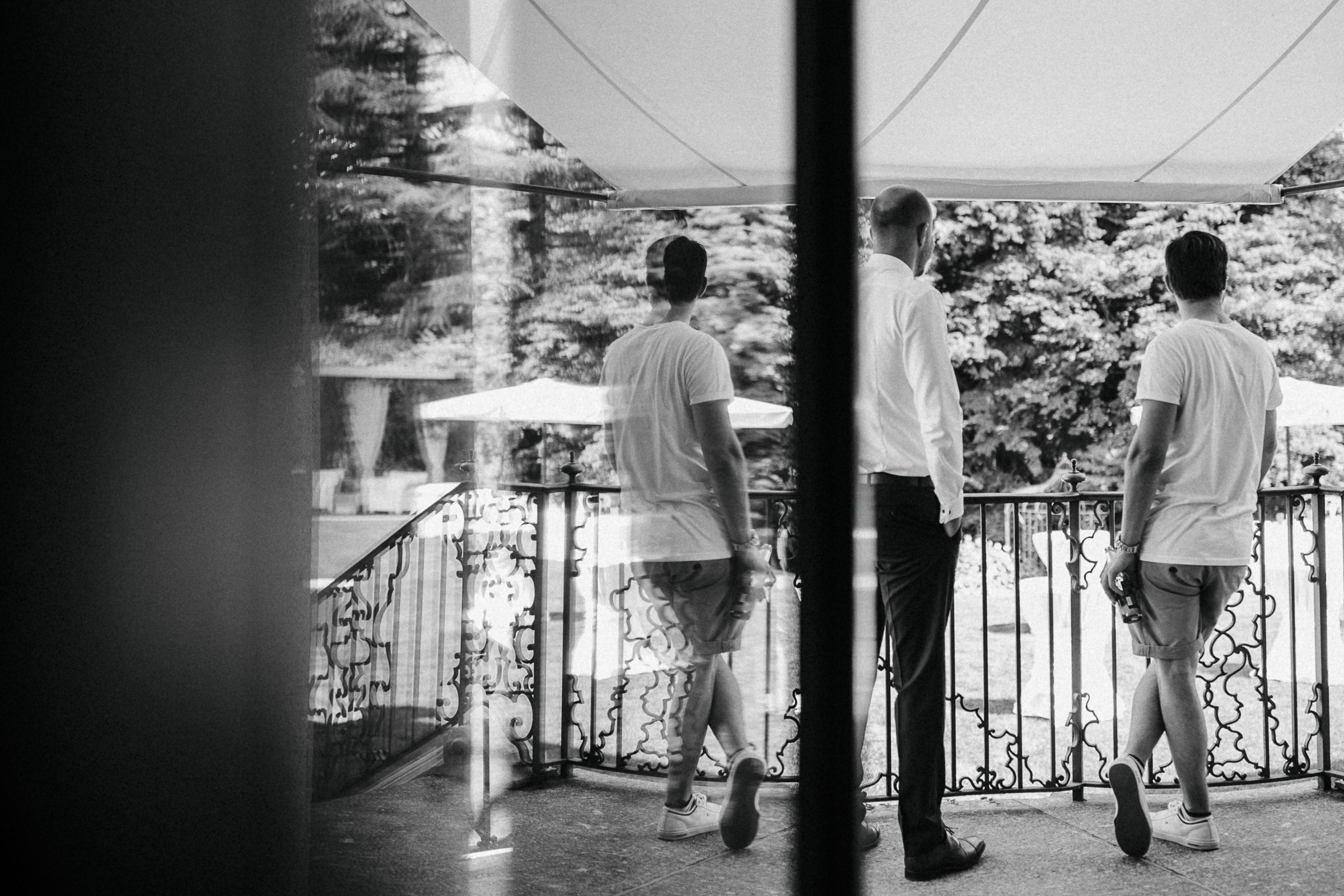 Hochzeit in Italien: zwei Männer auf dem Balkon der Villa schauen in den Garten