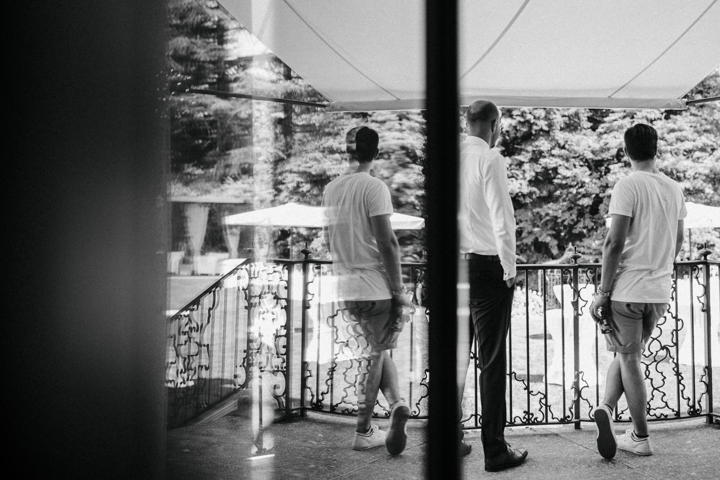 Hochzeit in Italien: zwei Männer auf dem Balkon der Villa schauen in den Garten