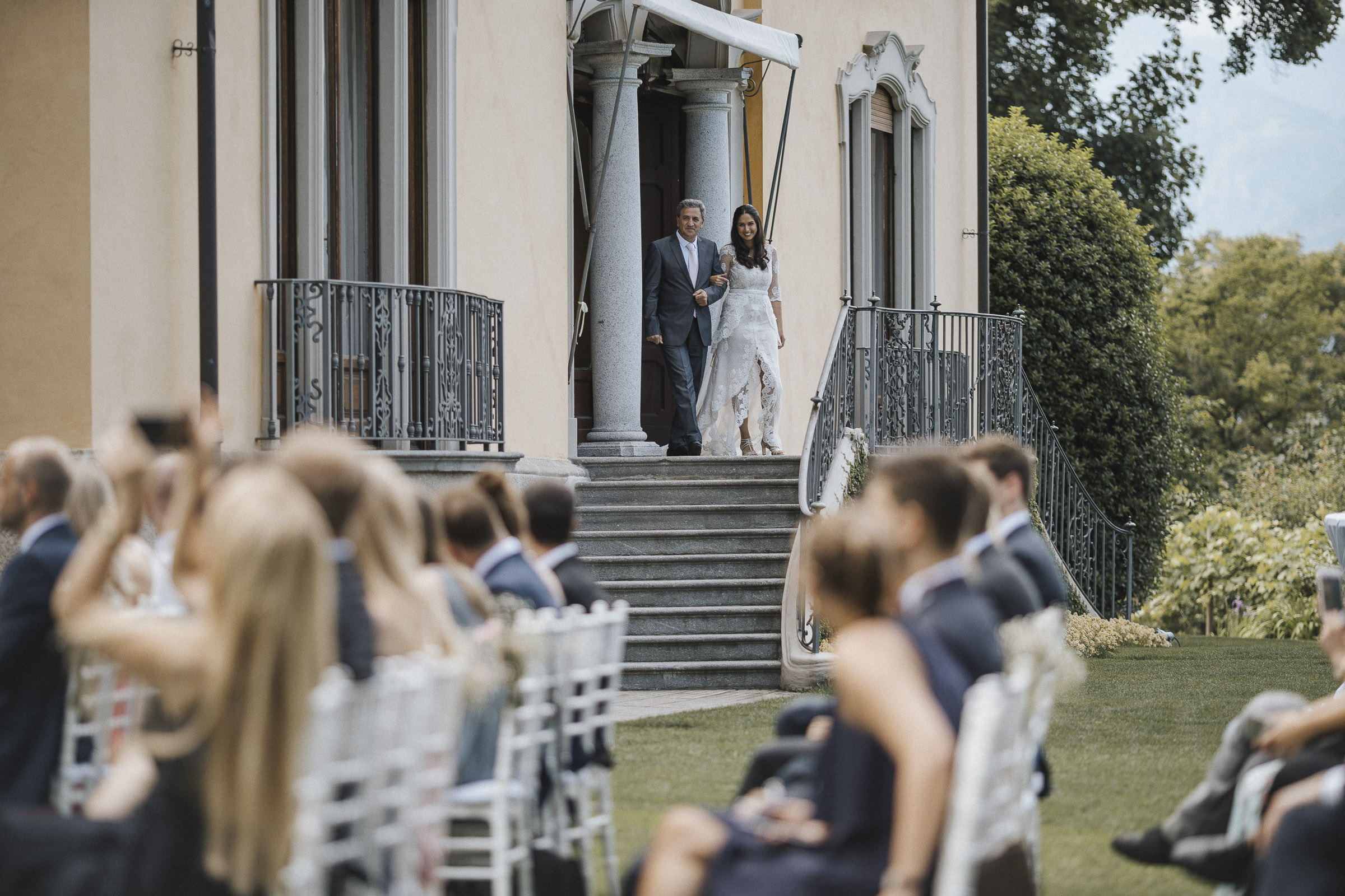 Hochzeit in Italien: die Braut kommt am Arm des Vaters aus der Villa
