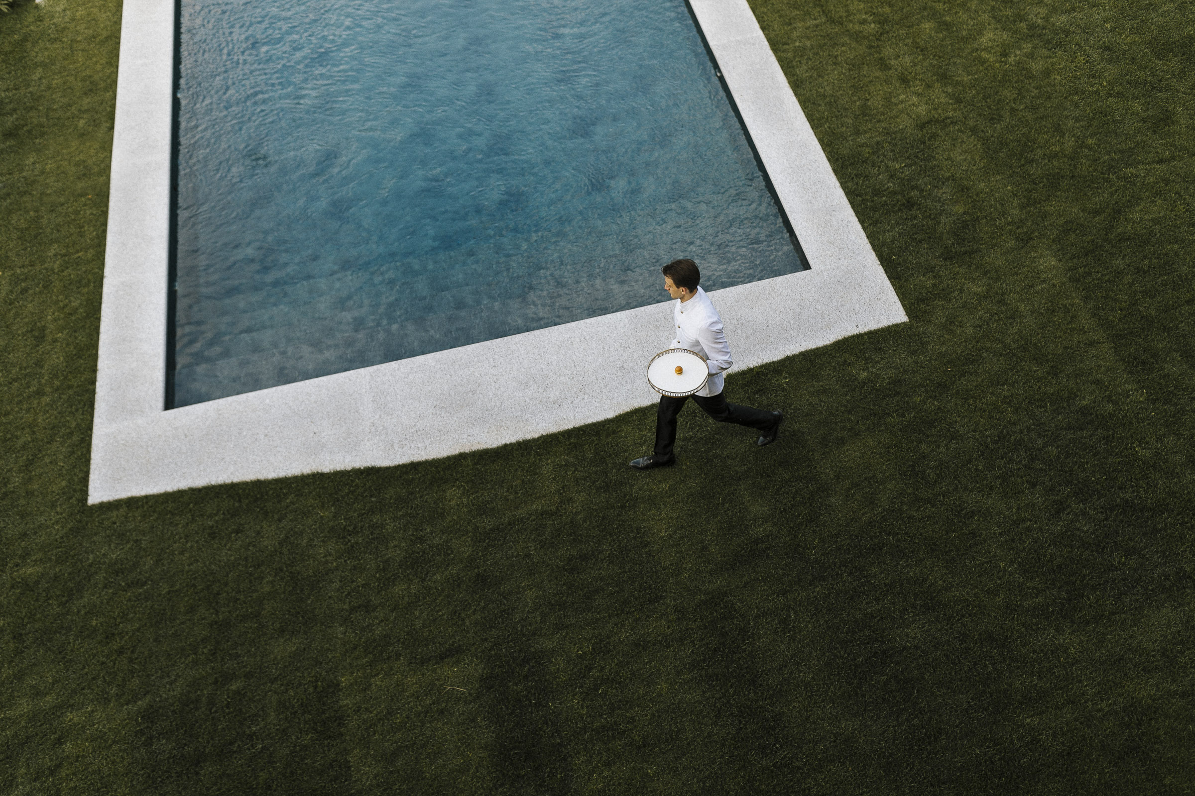 Hochzeit in Italien: ein Kellner läuft am Pool entlang