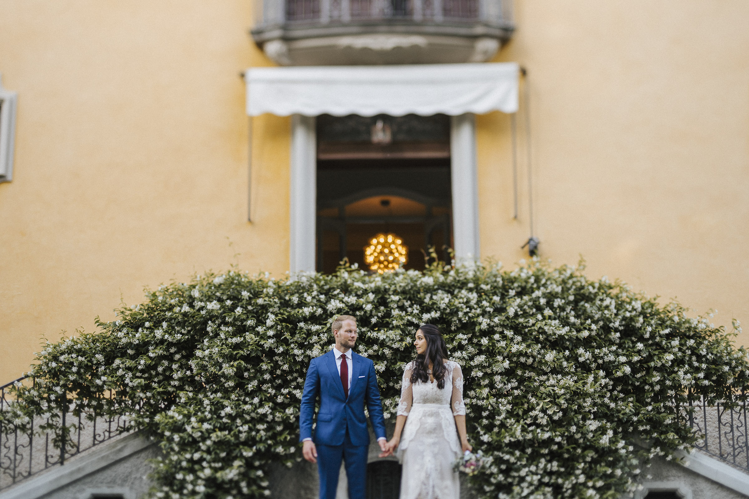 Hochzeit in Italien: Brautpaar Hand in Hand vor der Villa