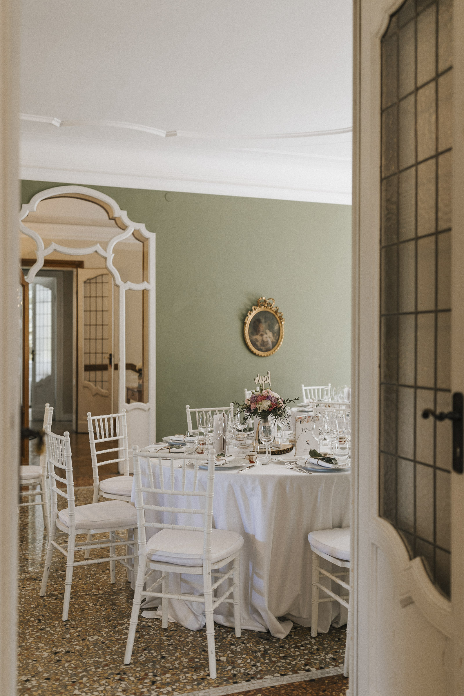 Hochzeit in Italien: Blick durch eine offen stehende Tür auf die dekorierten Tische