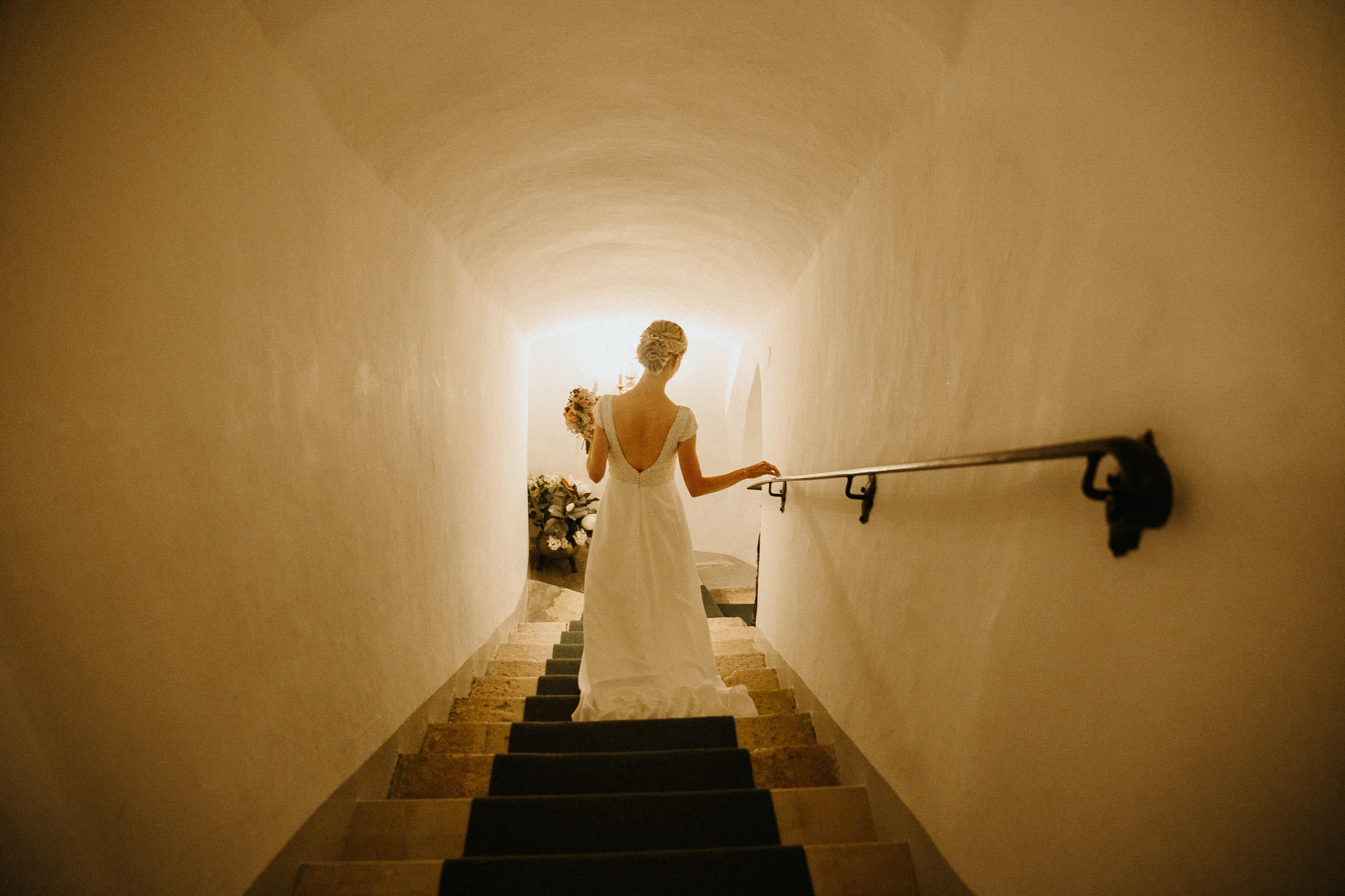 Schlosshochzeit: Braut steigt eine Treppe in ein Gewölbe herab