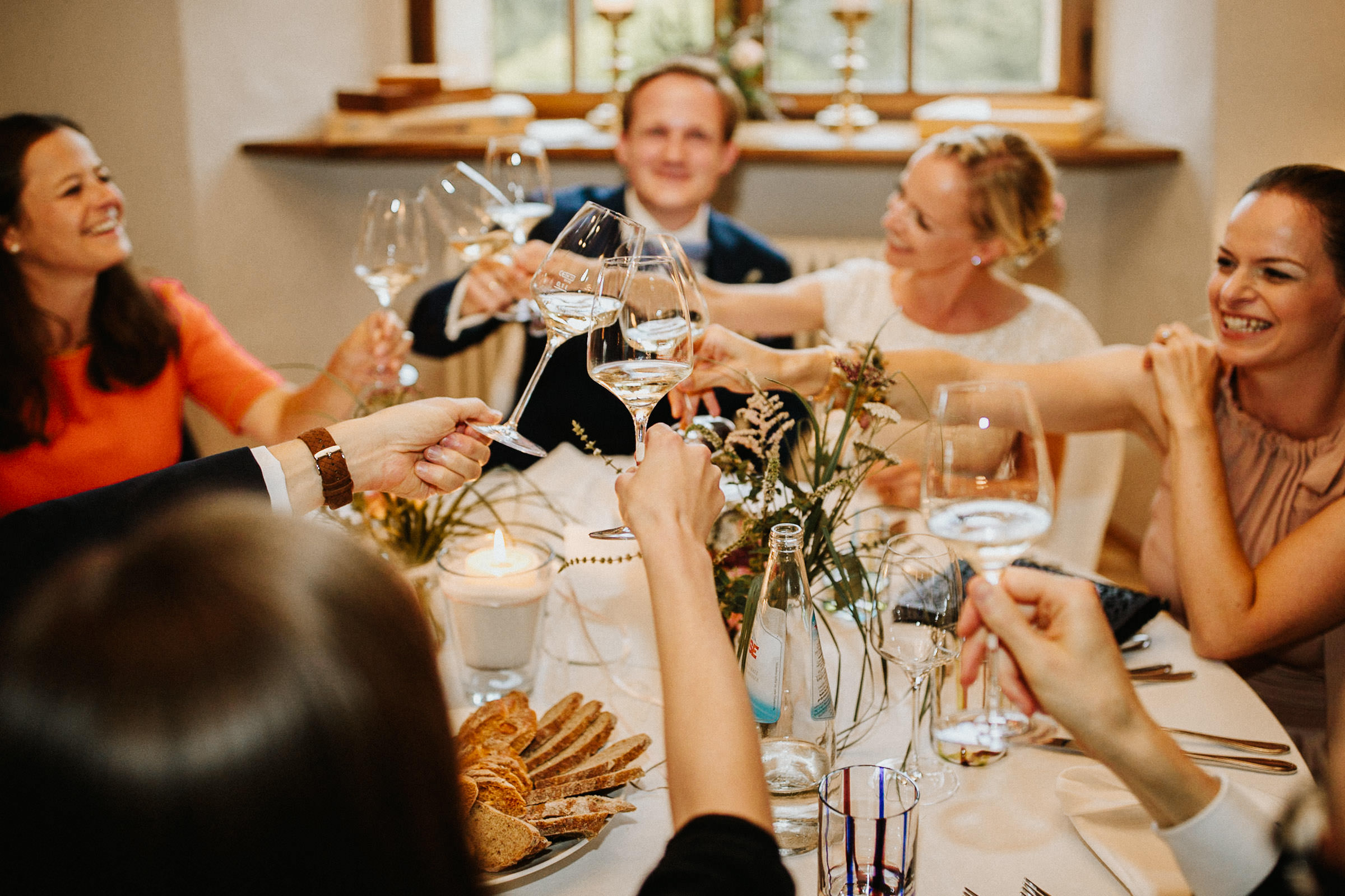 Schlosshochzeit: Brautpaar und Gäste stoßen an mit Weißwein