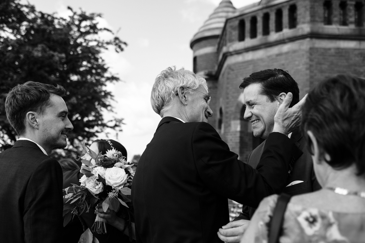 Strandhochzeit in Kiel: Ankunft des Brautpaares am Leuchtturm, Gast nimmt Bräutigam in den Arm