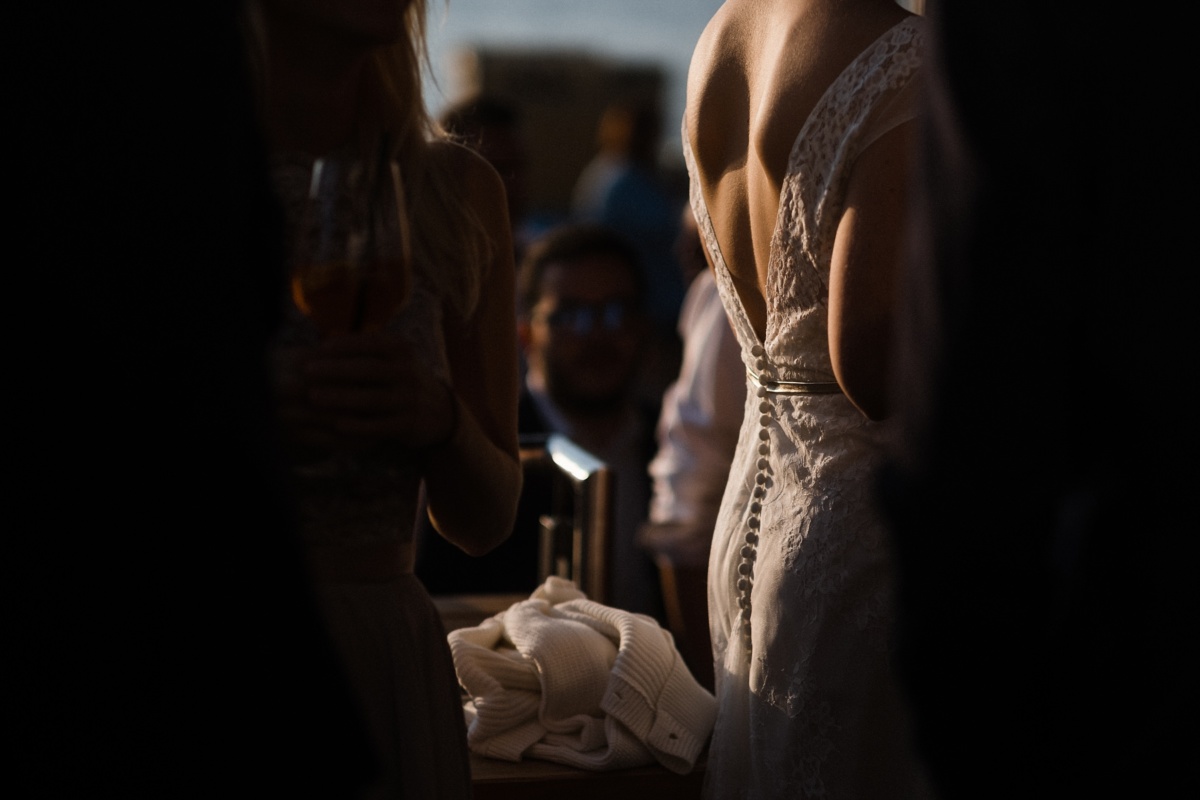 Strandhochzeit in Kiel: Rückenausschnitt der Braut im Gegenlicht.