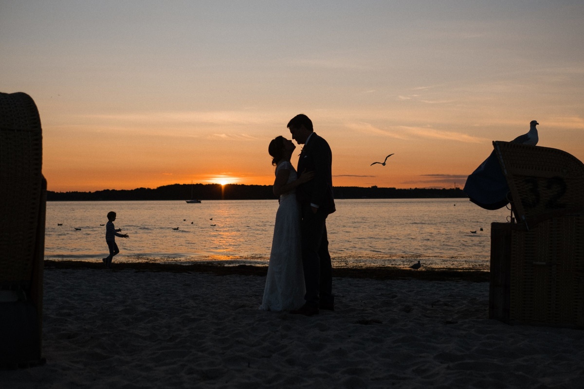 Strandhochzeit in Kiel: Silhouette des Brautpaares vor Sonnenuntergang.