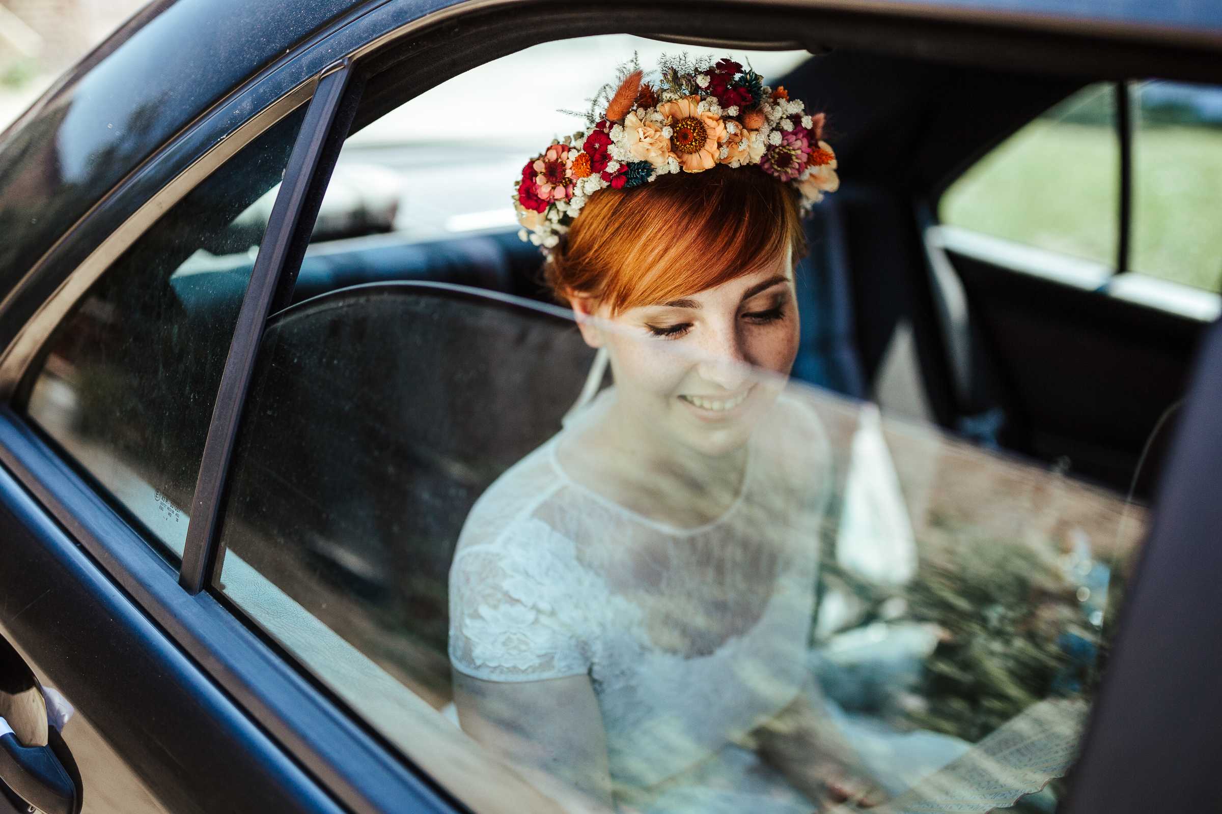 Blumenschmuck von Kopflegenden: Braut mit Blumekranz im Auto