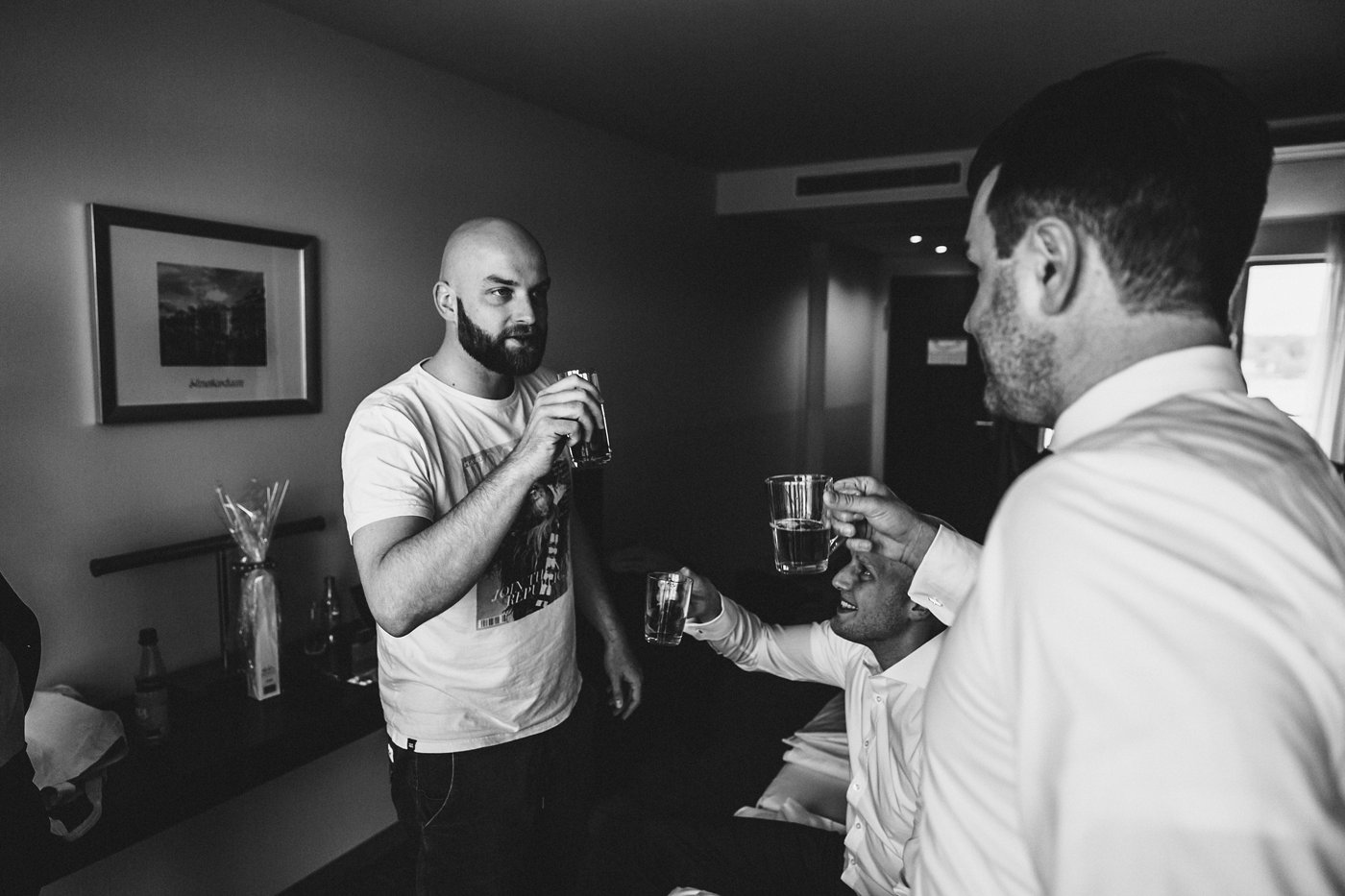 Urbane Hochzeit: Bräutigam trinkt mit Trauzeugen Rum beim Getting Ready
