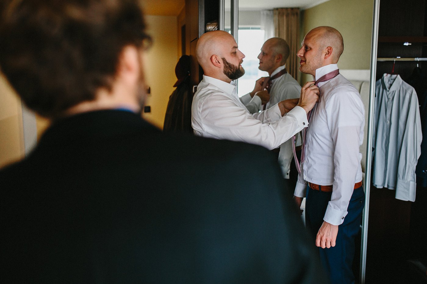 Urbane Hochzeit: Bräutigam bindet Trauzeugen die Krawatte