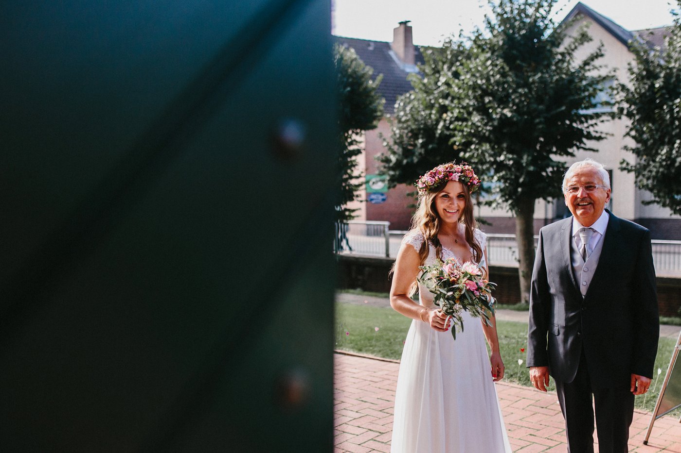 Urbane Hochzeit: Braut mit Brautvater vor der Kirche