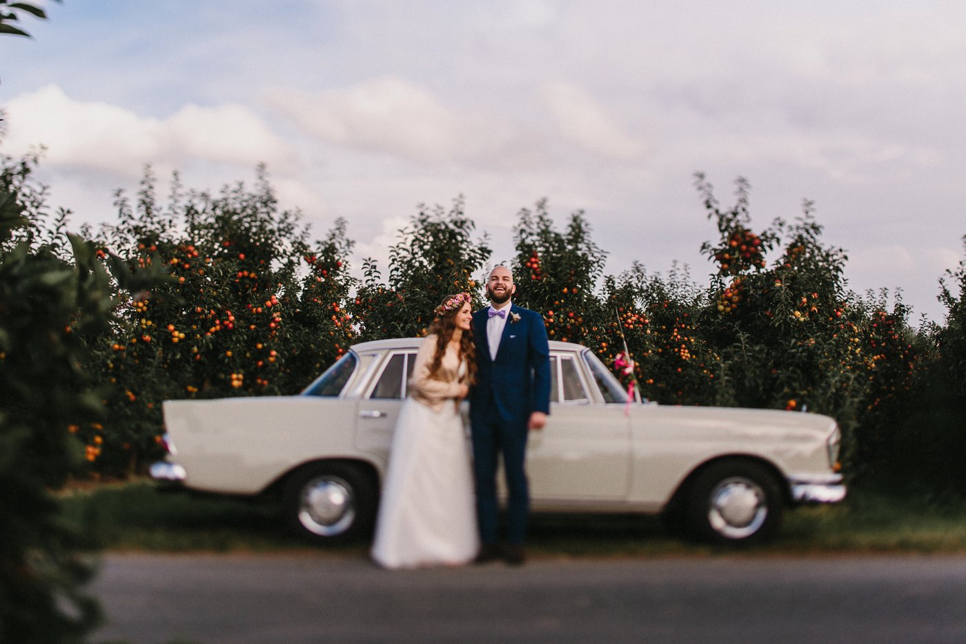 Urbane Hochzeit: Brautpaar vor dem Hochzeitsauto
