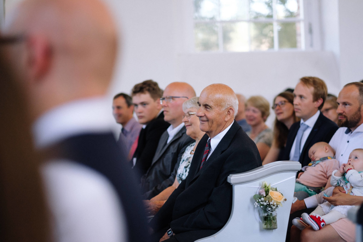 Vintage-Hochzeit: Hochzeitsgäste auf den Kirchenbänken
