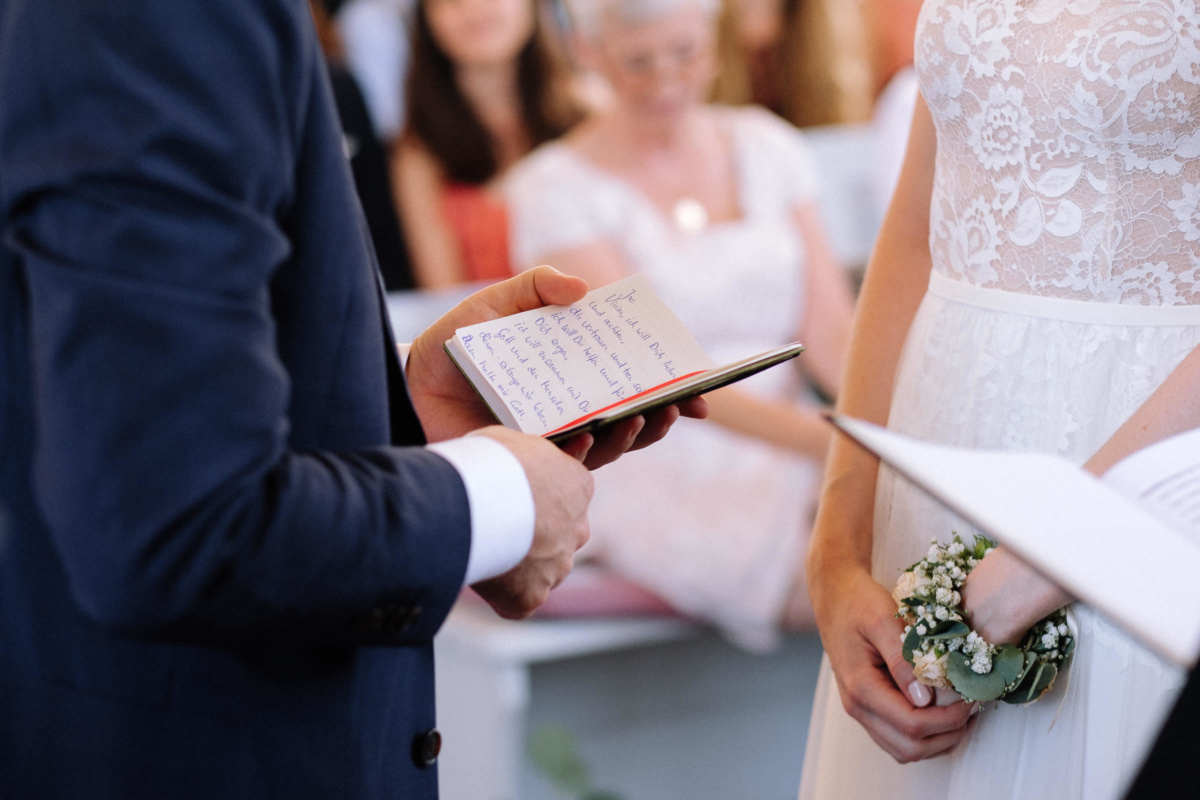 Vintage-Hochzeit: Bräutigam hält ein Buch mit seinem Ehegelöbnis in der Hand