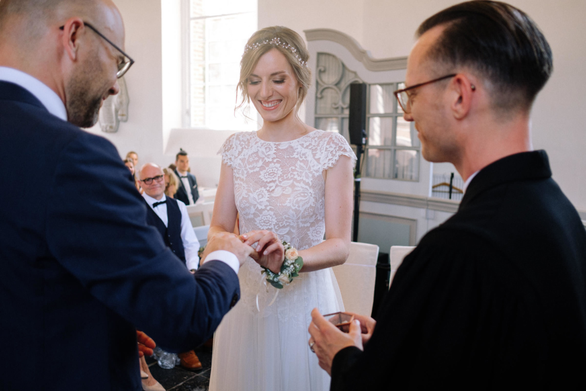 Vintage-Hochzeit: Bräutigam steckt der Braut den Ring an den FInger