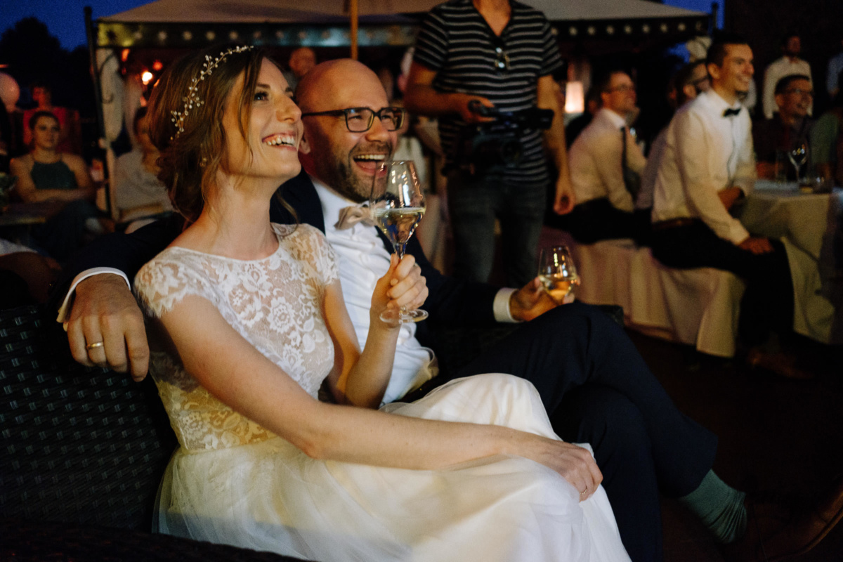 Vintage-Hochzeit: Brautpaar schaut lachend eine Präsentation