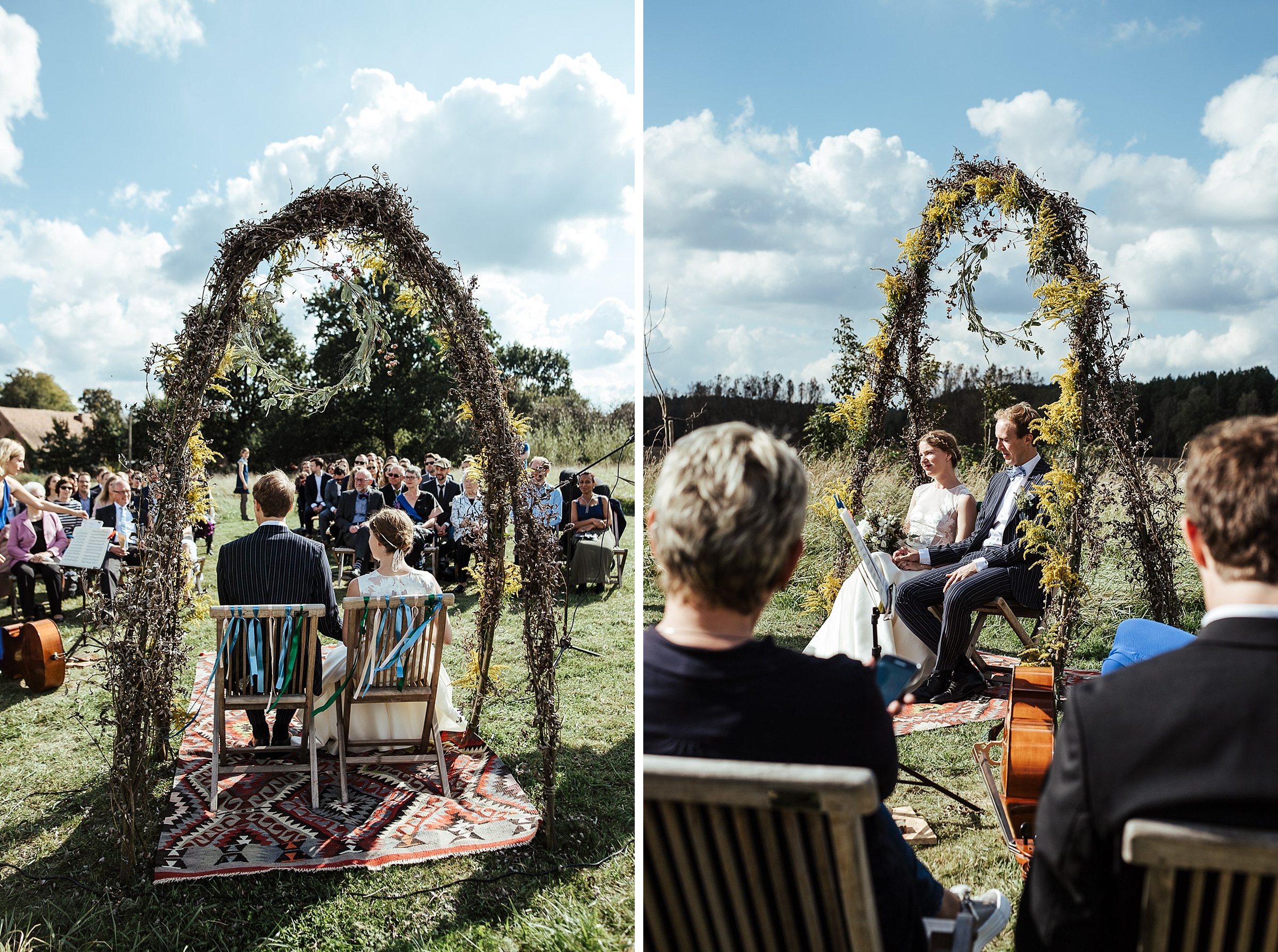 Landhochzeit: Brautpaar sitzt nebeneinander unter einem Kornblumenbogen