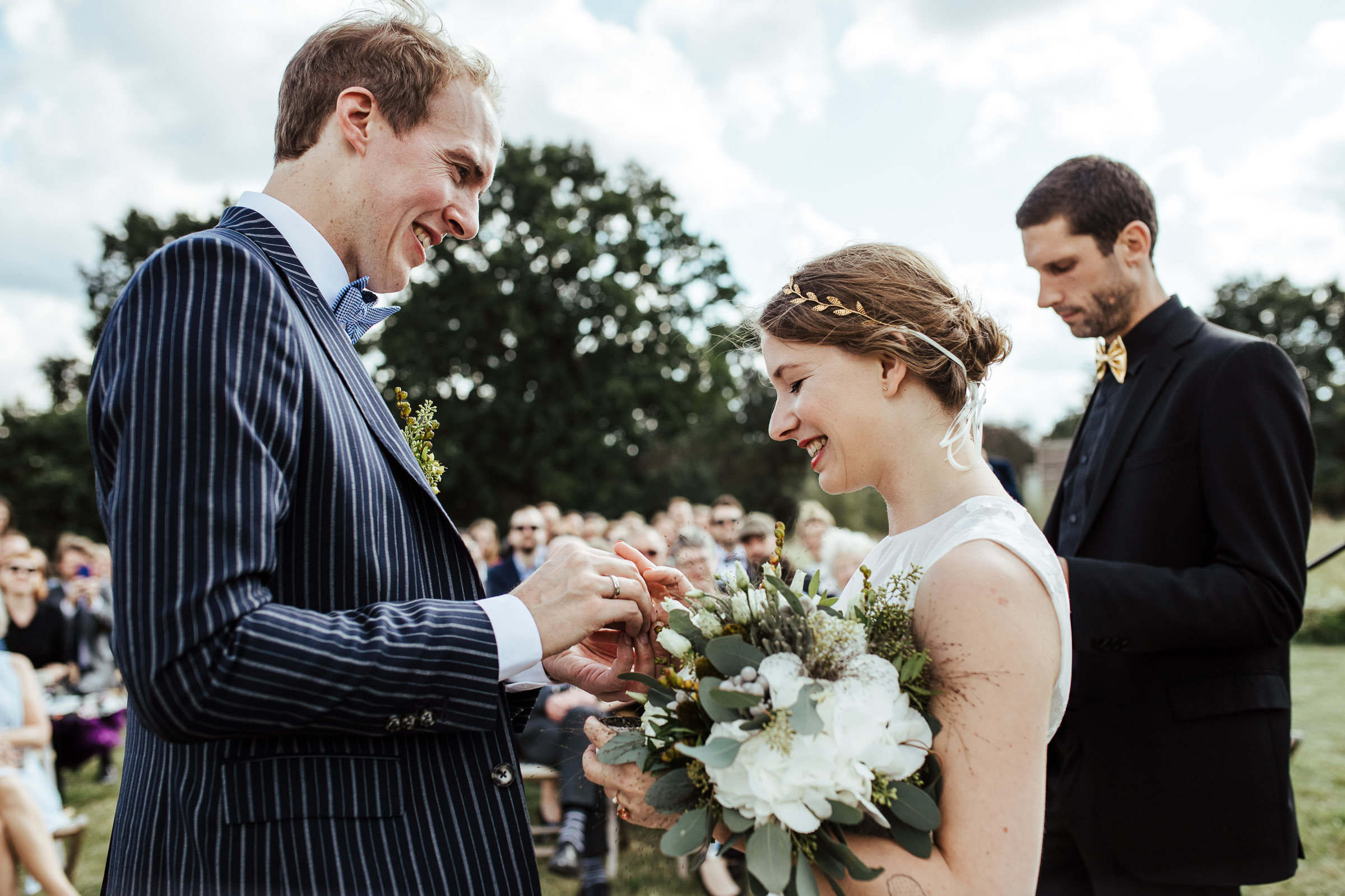 Landhochzeit: Bräutigam steckt der Braut den Ring an den Finger