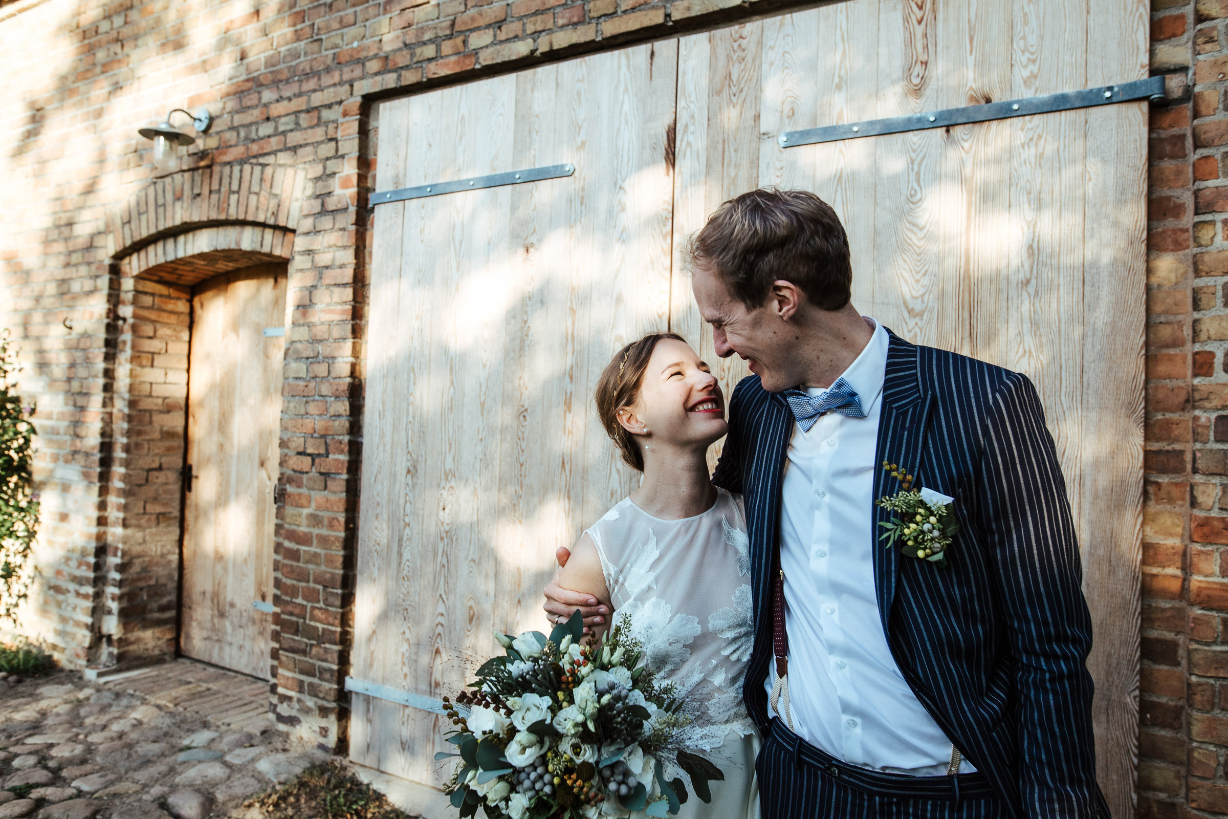 Landhochzeit: Brautpaarportrait vor Scheunentür