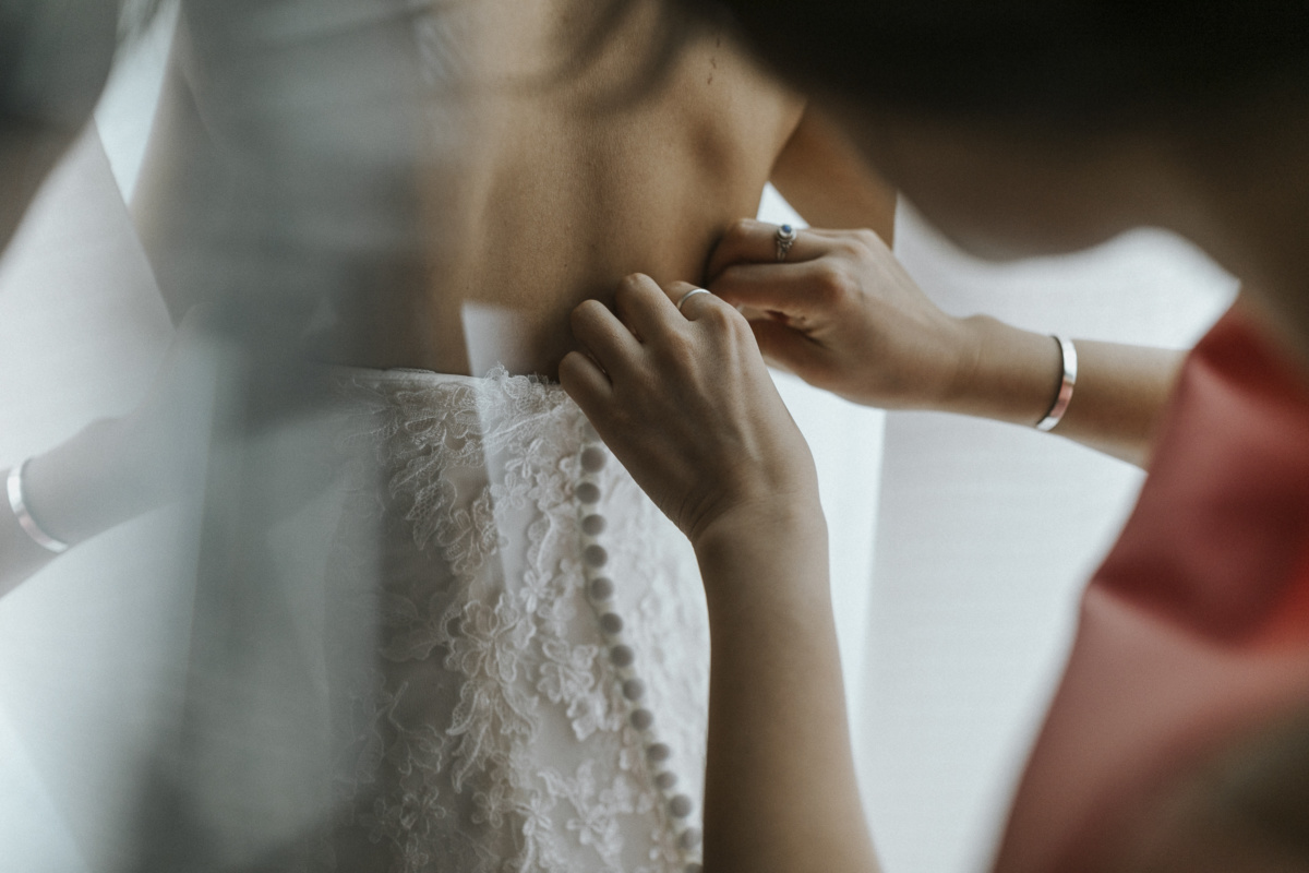 Hochzeitsfotograf in Augsburg: Brautkleid wird zugeknöpft