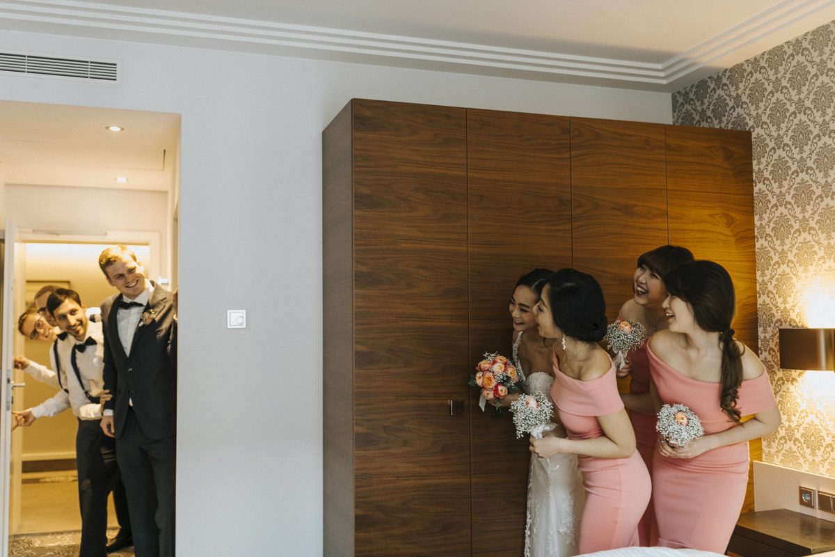 Hochzeitsfotograf in Augsburg: Trauzeuginnen und Braut verstecken sich vor Bräutigam und seinen Trauzeugen