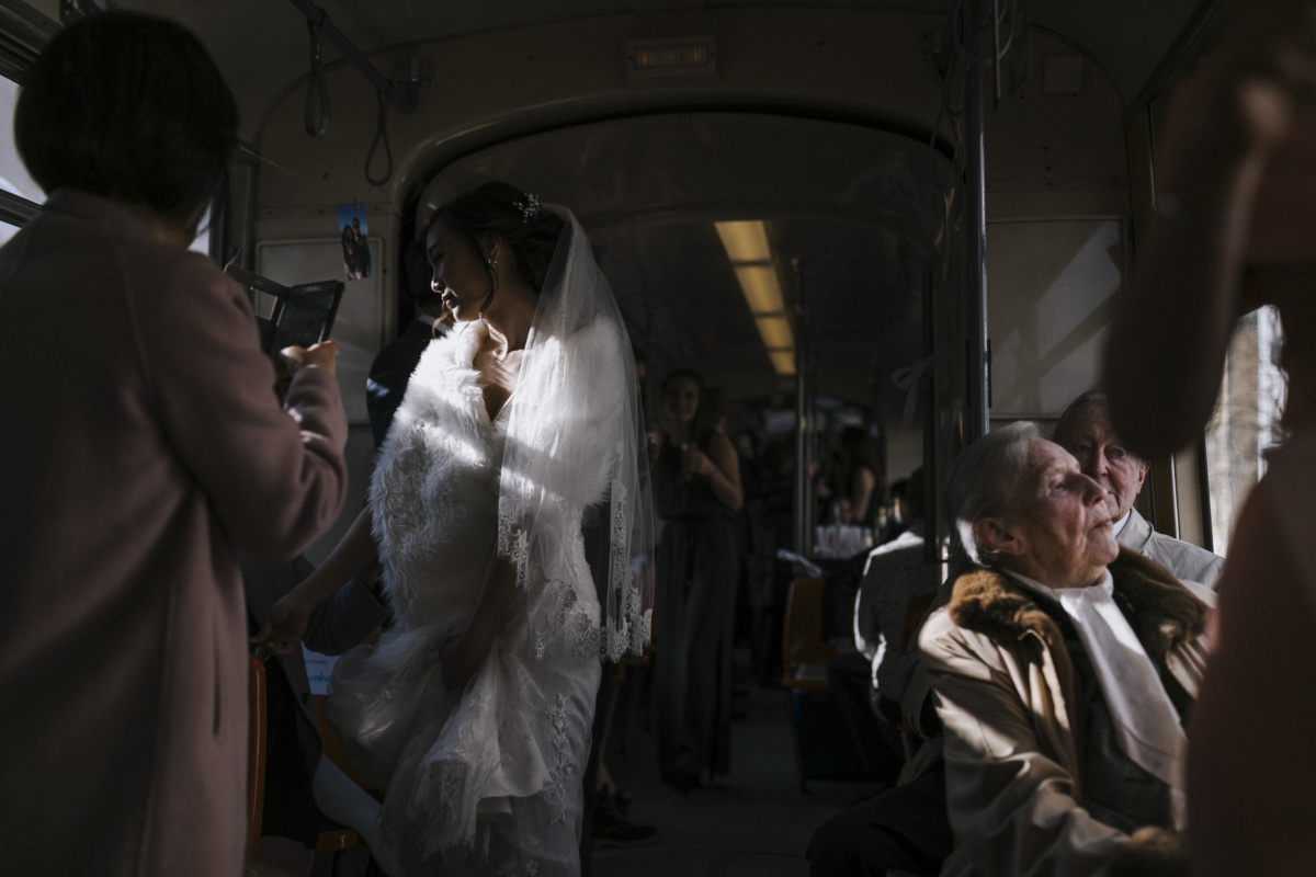 Hochzeitsfotograf in Augsburg: Braut in der Straßenbahn im Abendlicht